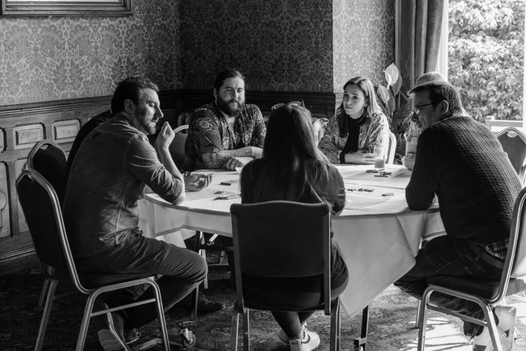 Black and white shot of a focused group discussion in a learning and development workshop.